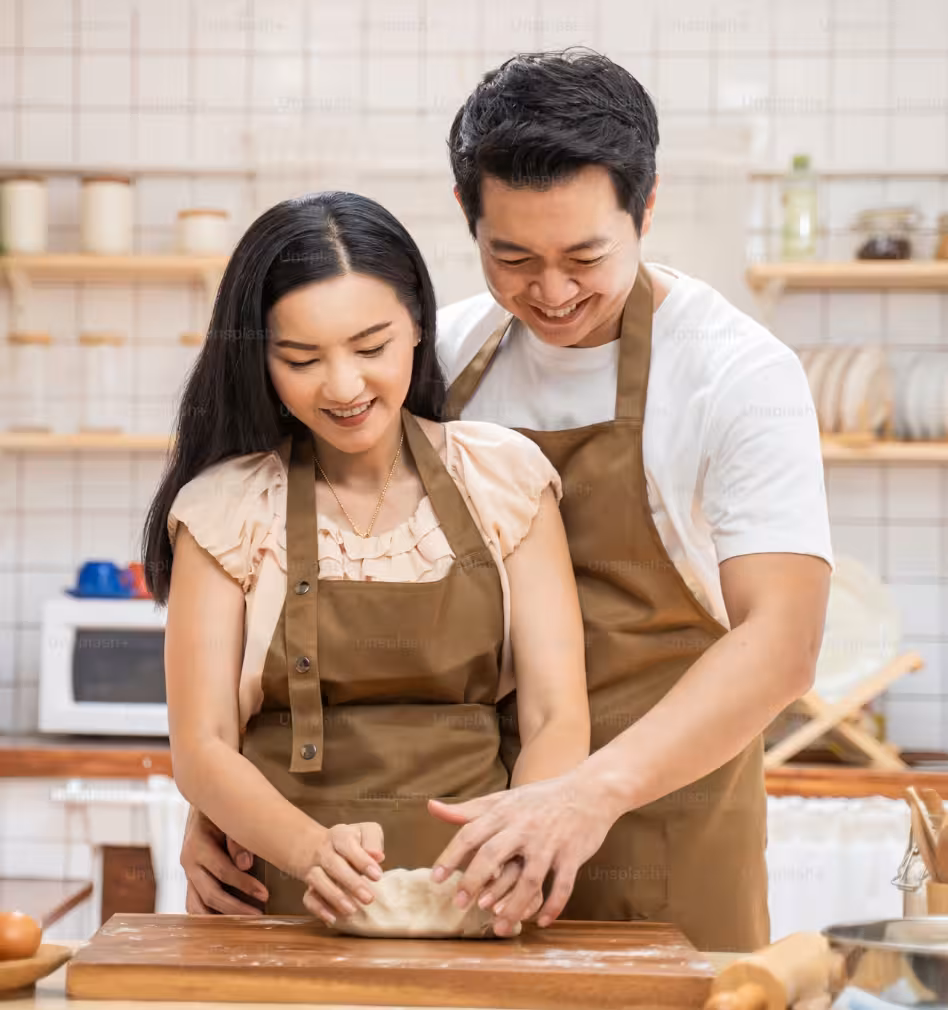 Vonado bakers smiling while kneading bread dough together in the bakery kitchen in Hanoi